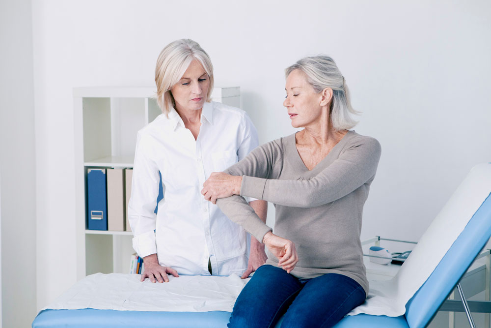 Healthcare-professional-assessing-a-patient's-range-of-motion-in-an-examination-room