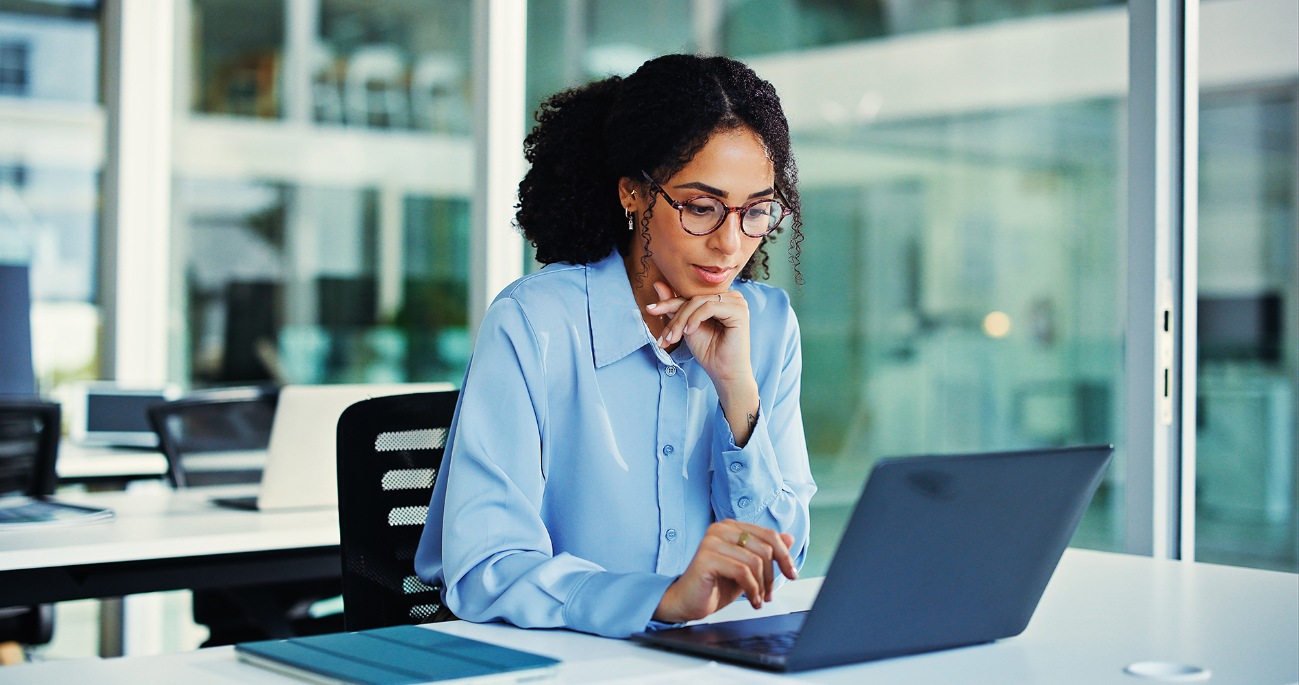 Woman using a laptop to explore the Assessment Center API Demo.